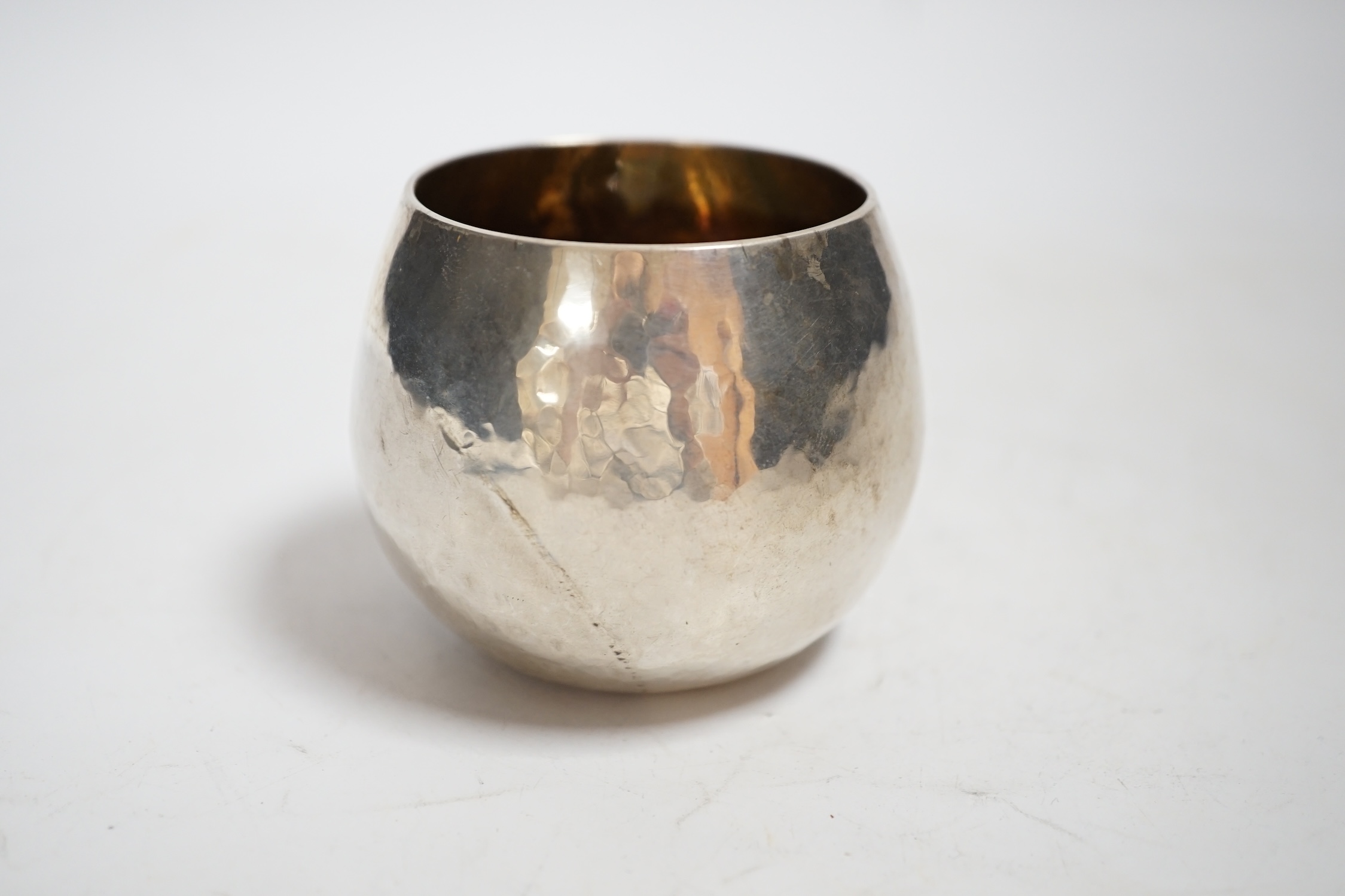 An Elizabeth II planished silver bowl with gilded interior, maker, C.M.H, London, 1985, height 57mm, 3.9oz.